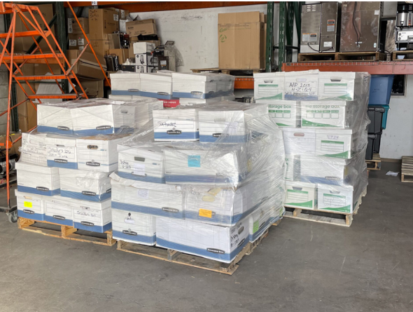 Warehouse pallets stacked with shrink-wrapped cases of product on wooden pallets — sample photo for image analysis